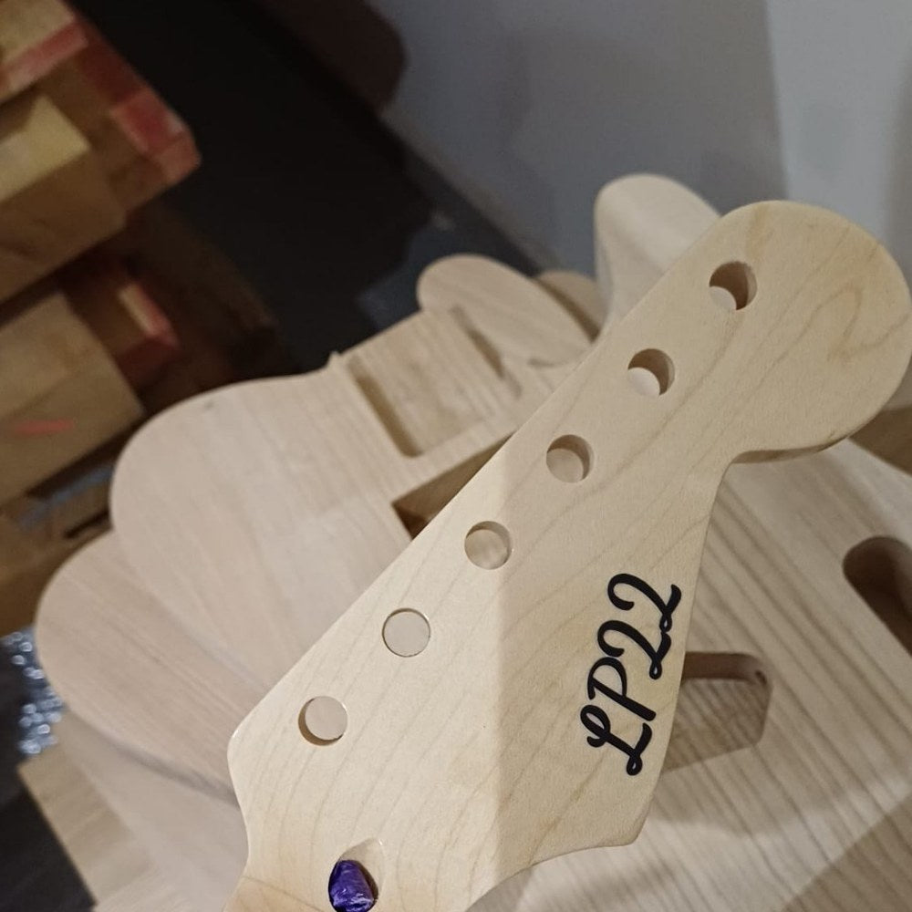 Black script LP22 custom logo waterslide decal on an unfinished maple headstock