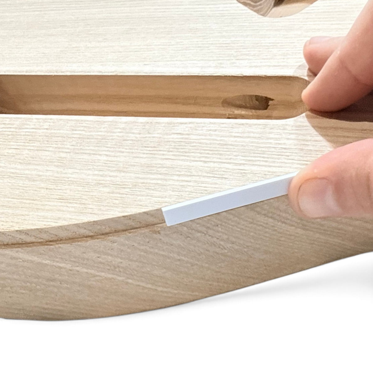 Binding strip fitted along the edge of the guitar body