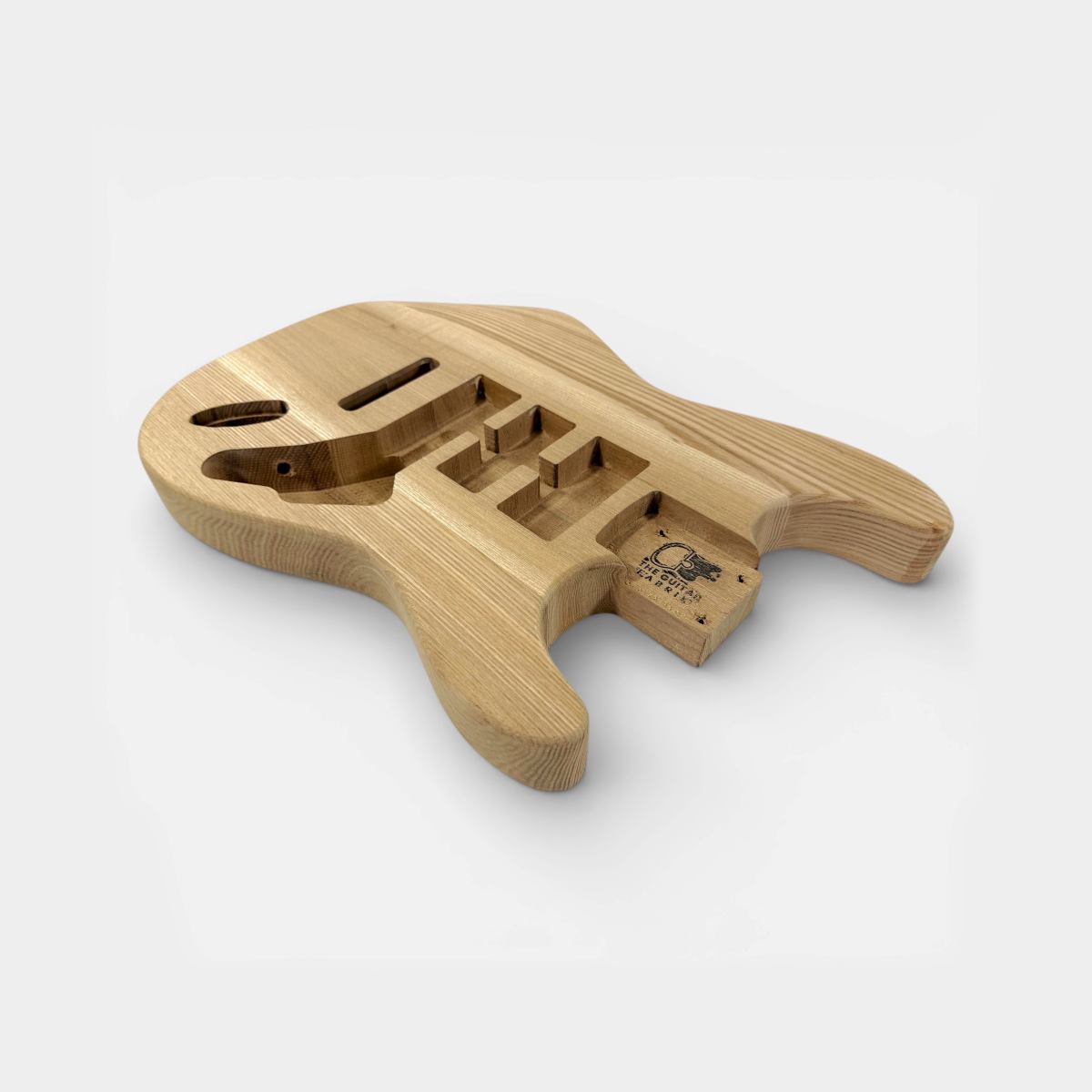 side view of strat style guitar body with pre-cut electronics slots