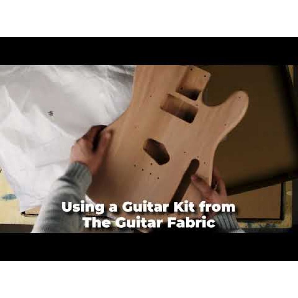 Instructional video still showing hands assembling guitar body from The Guitar Fabrik DIY kit