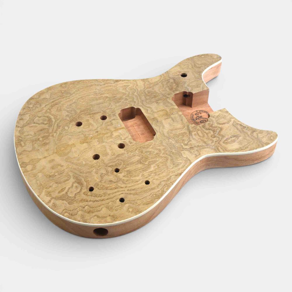 Three-quarter view of bare double cut mahogany body with ash burl veneer and routing cavities