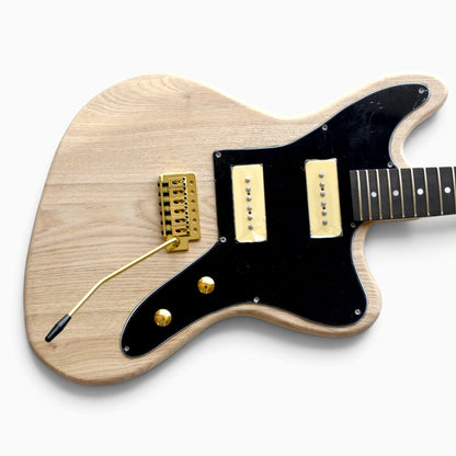 Close-up of the ash body with black pickguard, two soapbar pickups, gold bridge, gold knobs and tremolo arm fitted