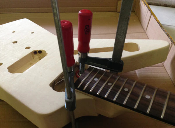 gluing and clamping neck into the guitar body